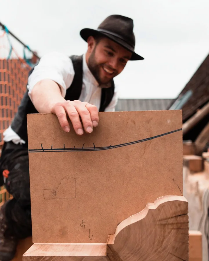 Joshua Korn bei der Arbeit an einem zugeschnittenen Holzbauteil