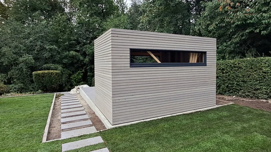 Fertiges Gartenhaus mit Holzfassade und angelegter Terrasse