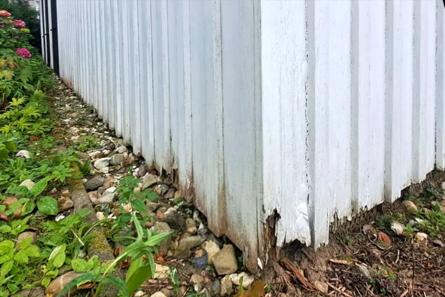 Sanierte Außenwand mit neuer senkrechter Holzverkleidung