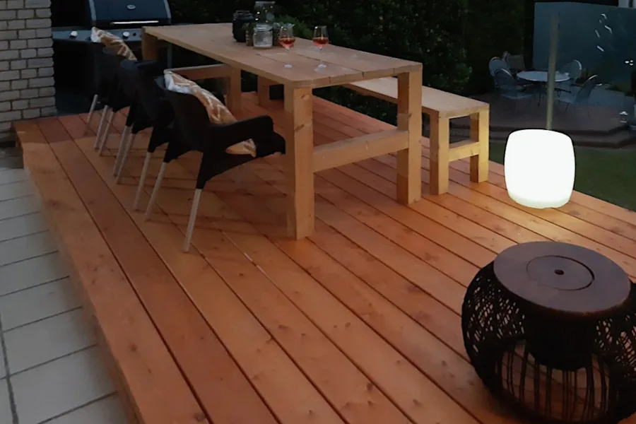 Holzterrasse mit Tisch und Bänken